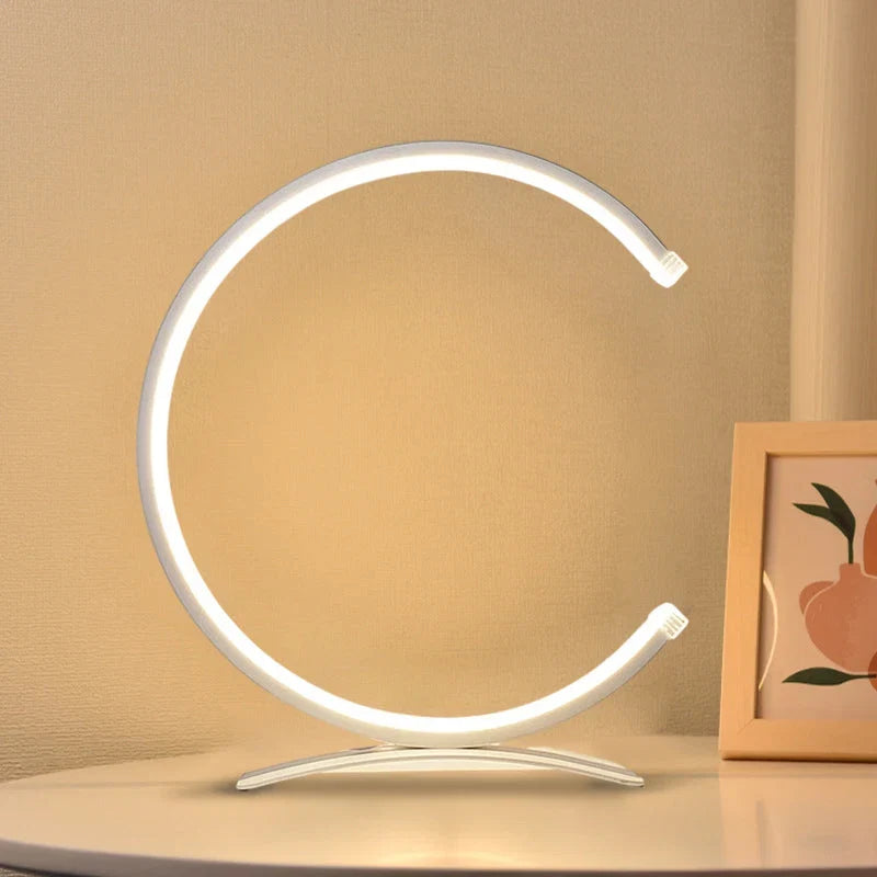 C-formad lampa som lyser upp ett skrivbord