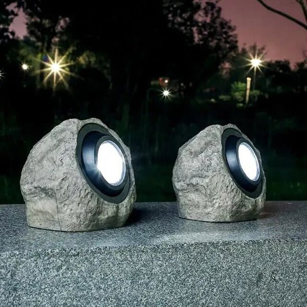 Solarlampa i stenlook som lyser upp en gång i trädgården