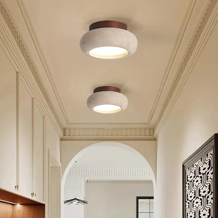 Rund plafondlampa i beige travertin med trädetaljer