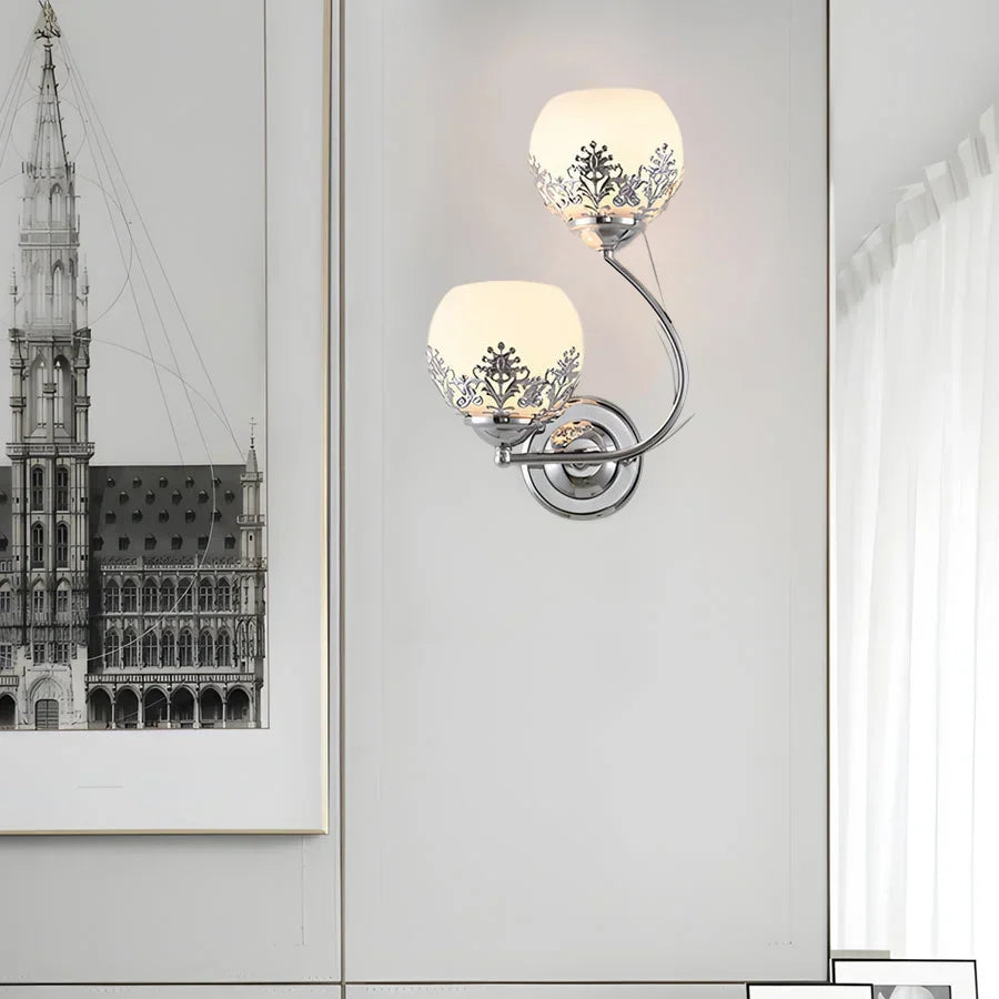 Vägglampa i blommig stil som sprider ett mjukt sken