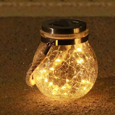 Solarlampa i glas som lyser upp uteplats eller trädgårdsmiljö