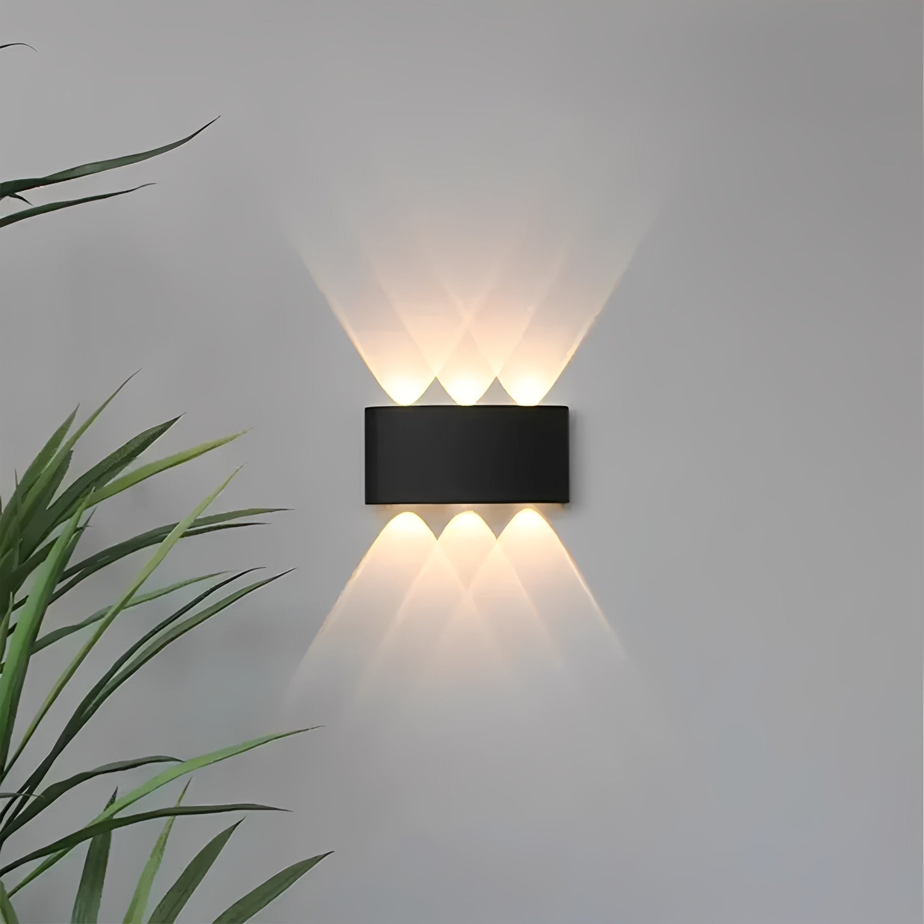 Svart modern LED-vägglampa med varmvit belysning monterad på vägg