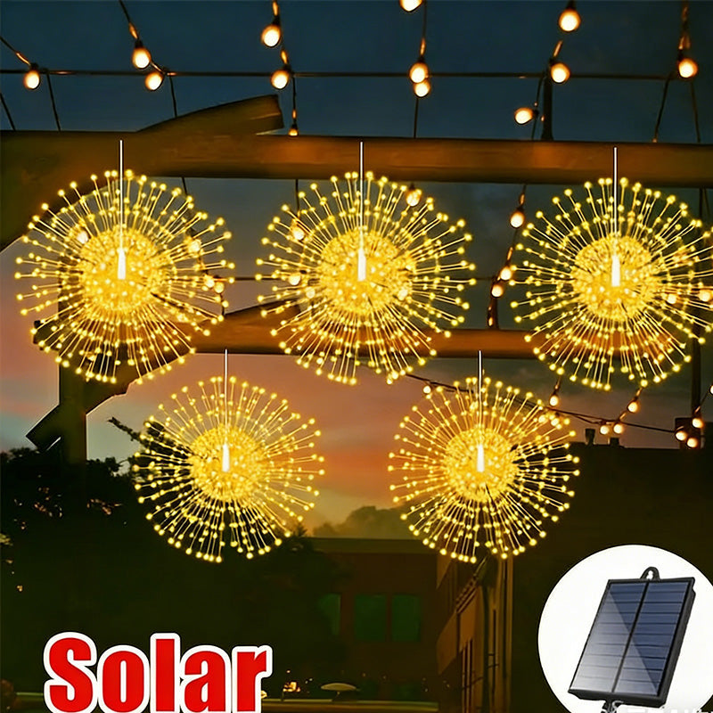 Solarlampa med fyrverkerieffekt placerad i trädgården i skymning