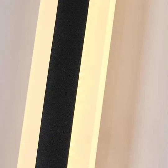 Antracit vägglampa tänd på husvägg i kvällsmiljö