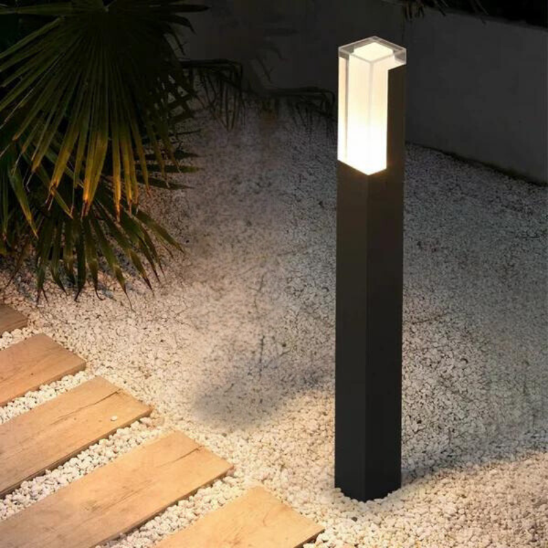 Utomhusvägglampa monterad vid entré som ger modern fasadbelysning
