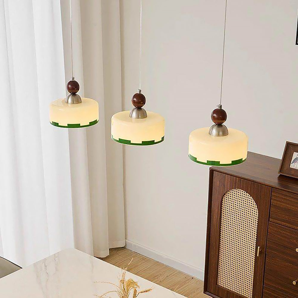 Detaljbild på beige lampskärm och träinslag på pendellampa