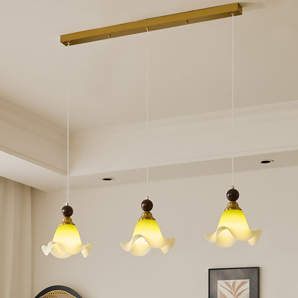 Närbild av taklampa med vågformad akrylskärm och detaljer i trä