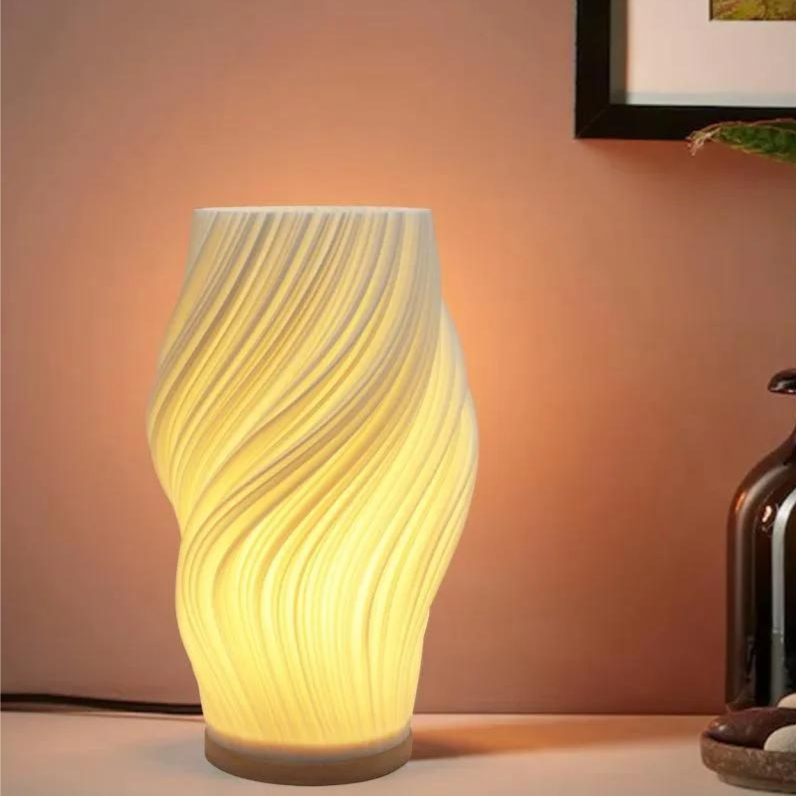 Modern LED-bordslampa med skulptural vågform sedd framifrån