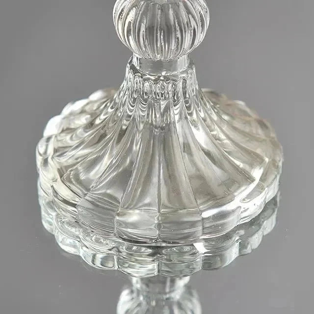 Cylinderljus placerat i en dekorativ ljusstake i glas