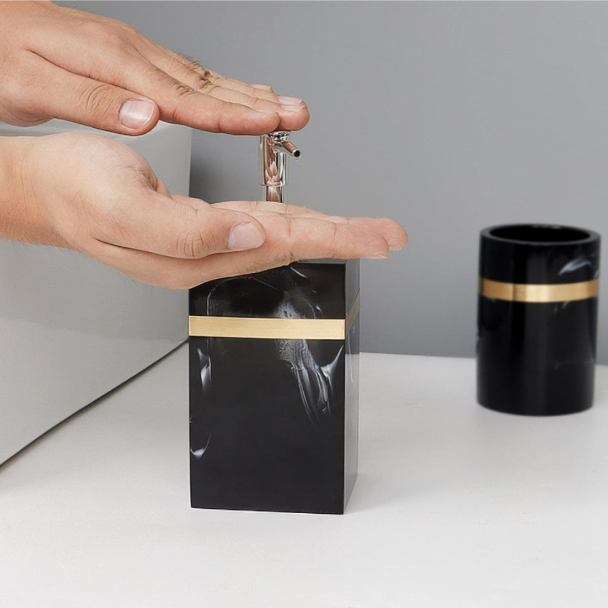Badrumsaccessoarer i svart imitationsmarmor med eleganta gulddetaljer